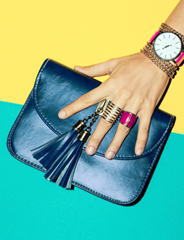 Image of a model holding a bag in a blue dress